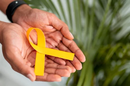 image illustrant deux mains tenant un ruban, symbole jaune de la lutte contre l'endométriose