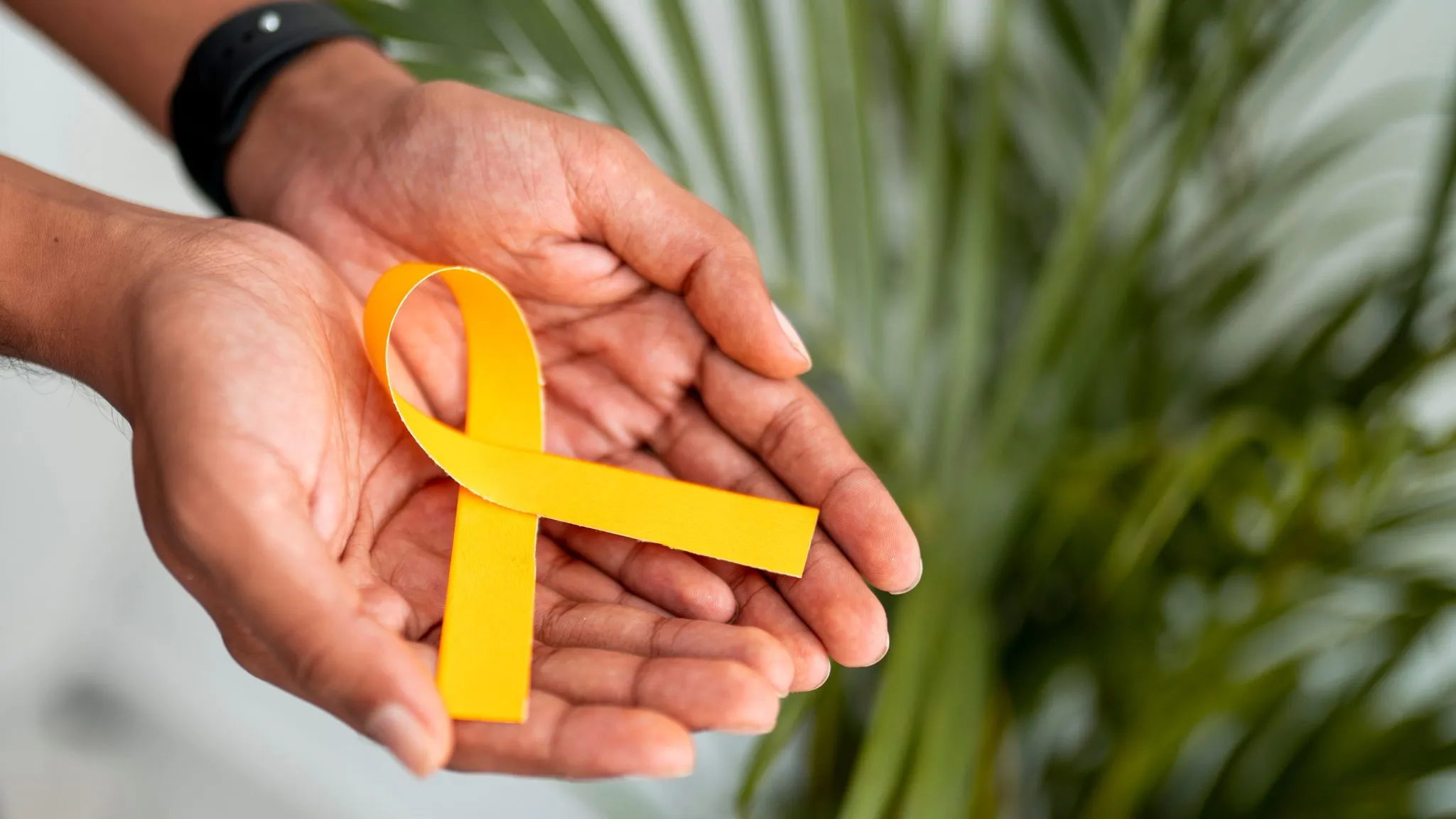 image illustrant deux mains tenant un ruban, symbole jaune de la lutte contre l'endométriose