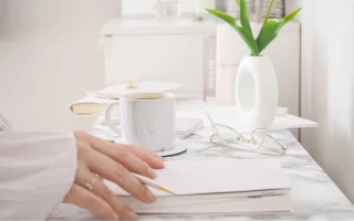 image illustrant des mains de femmes entrain d'écrire mon histoire avec l'endométriose sur un bureau