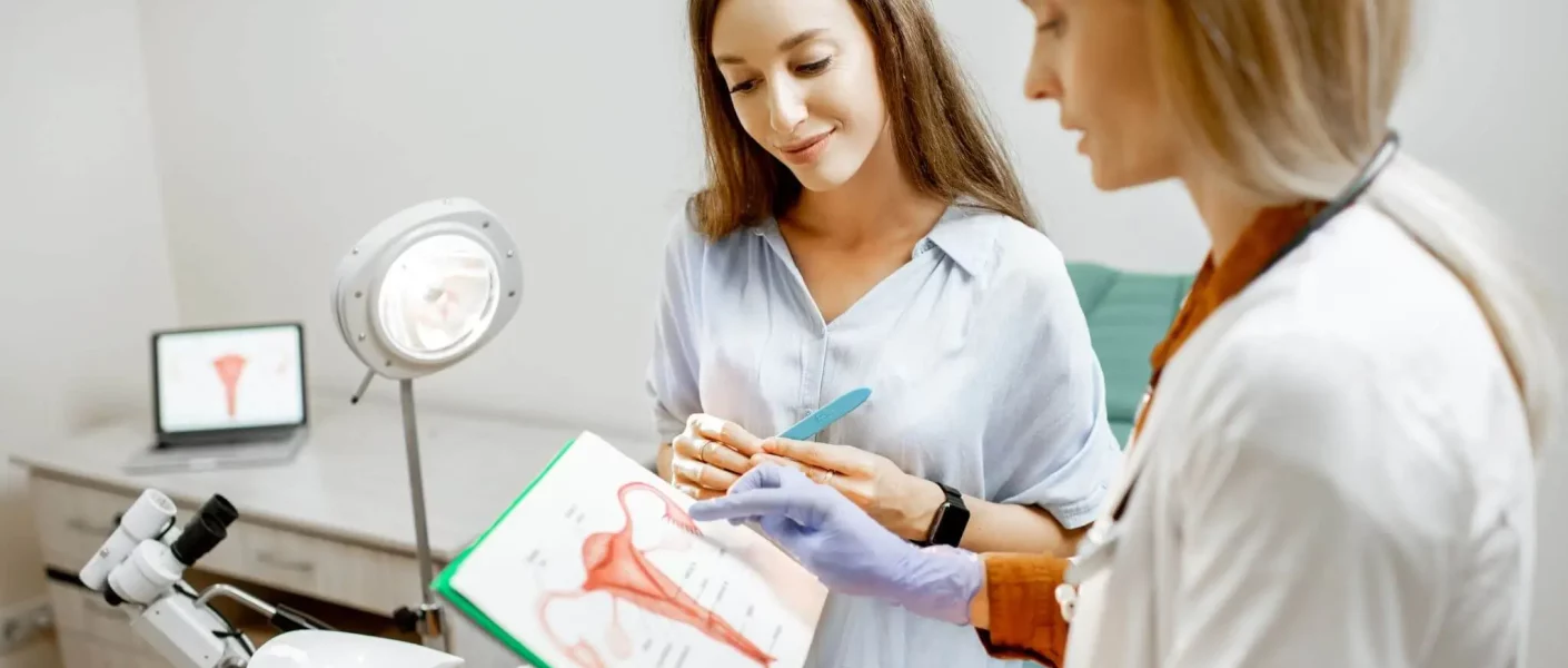 image illustrant une femme en consultation avec une gynécologue qui lui explique via un schéma d'utérus la pathologie et lui apporte des réponses pour l'article diagnostic de l'endométriose